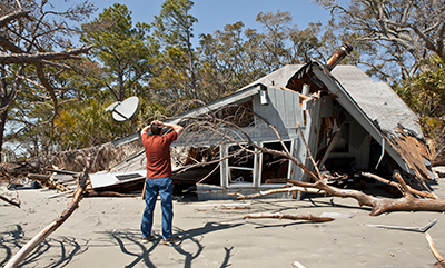 man-in-front-of-house-destroyed-by-storm