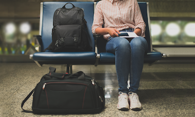 young woman sitting with luggage at airport