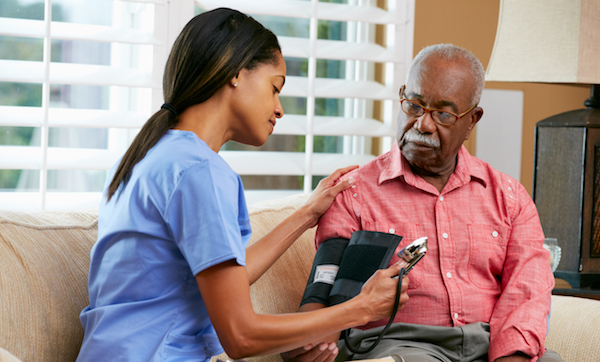 Nurse Visiting Senior Male Patient At Home