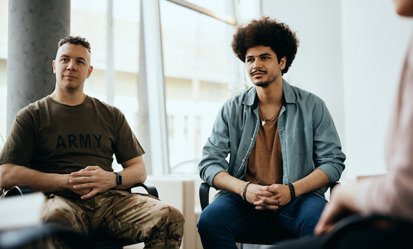 Two men participating in group therapy at community center.
