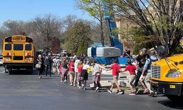 Children from The Covenant School, a private Christian school in Nashville, Tenn., hold hands as they are taken to a reunification site at the Woodmont Baptist Church after a shooting at their school