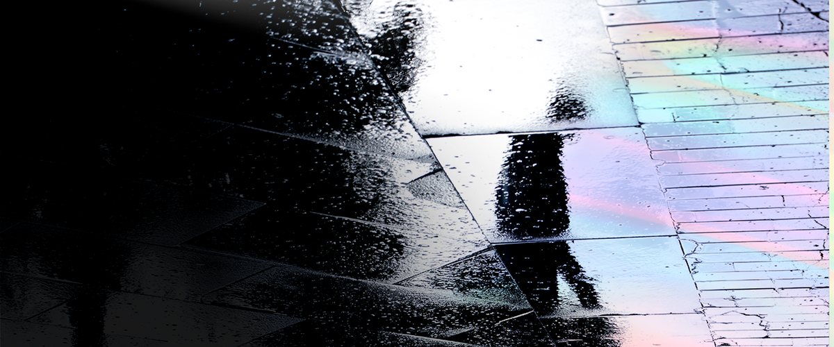 Shadow of a person visible on wet and oily ground