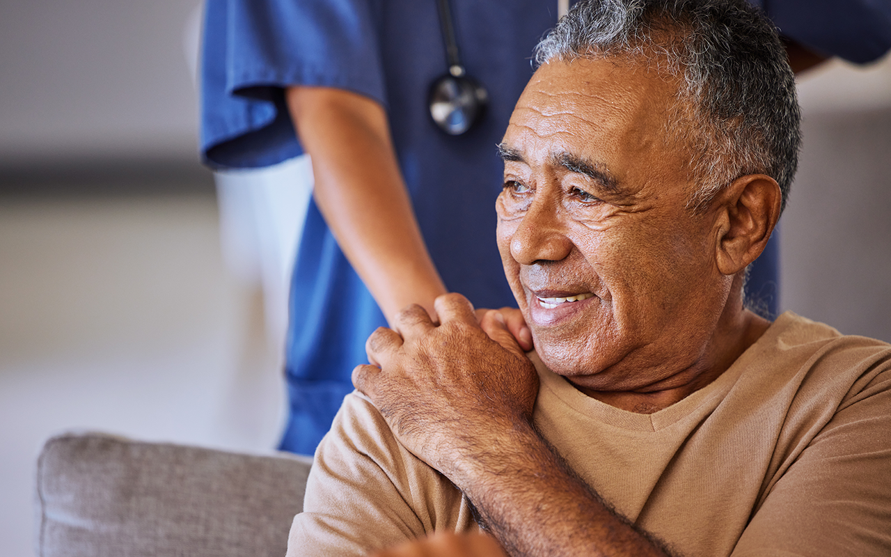 Nurse places hand on elderly man's shoulder