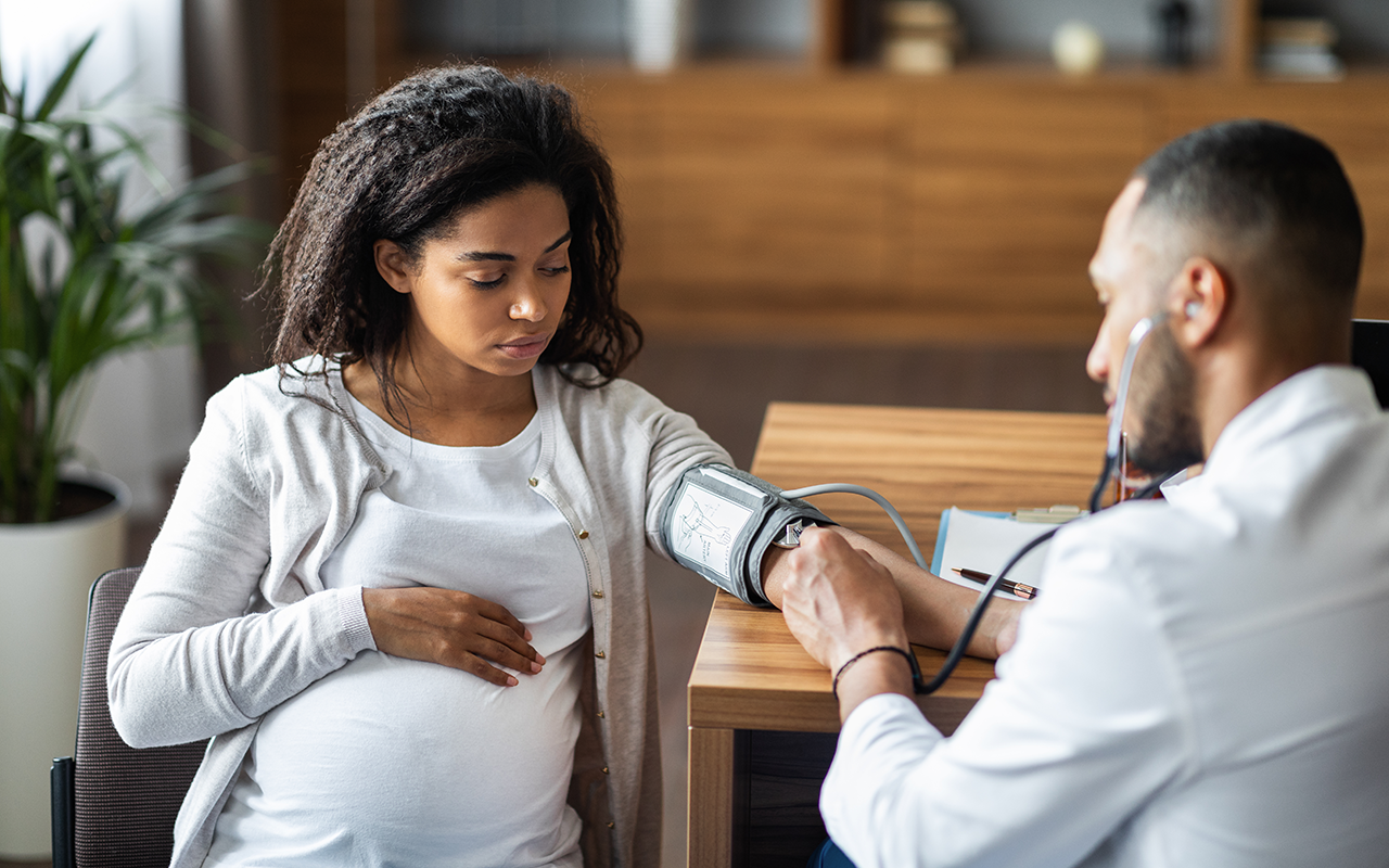Doctor takes the blood pressure of a pregnant woman
