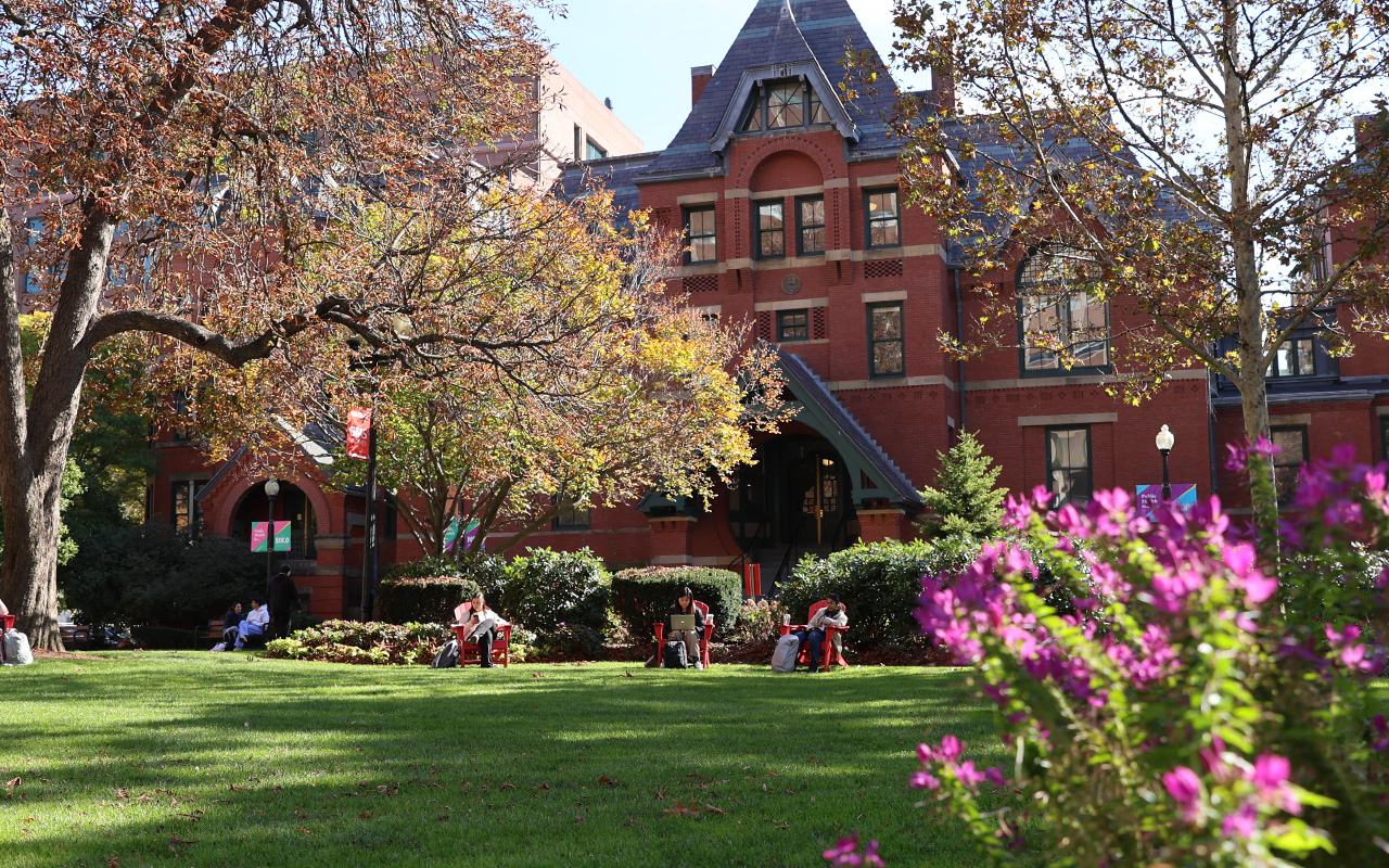 Students sit on chairs working outside of Talbot building