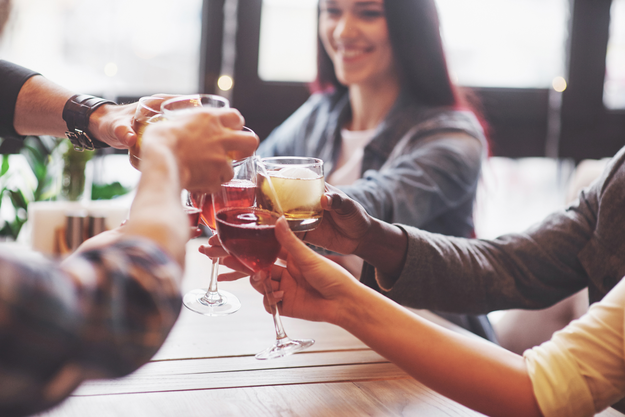 Hands of people with glasses of whiskey or wine, celebrating and toasting in honor of the wedding or other celebration.