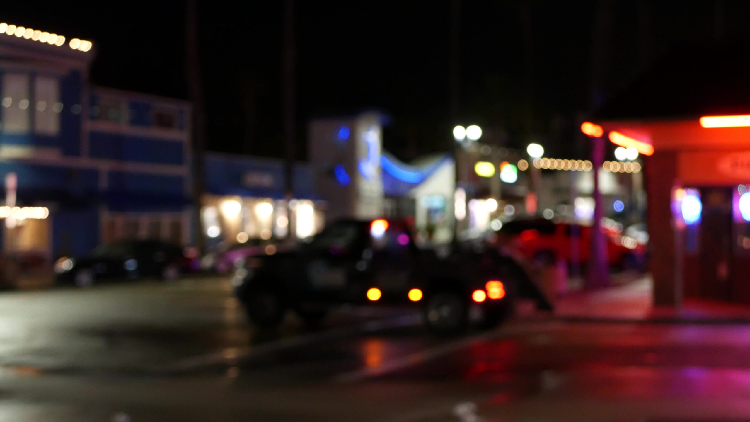Defocused evening street. Lights of city, cars on rainy night. Road in soft focus.