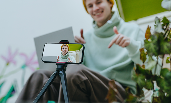 Man filming himself on a phone held by a tripod