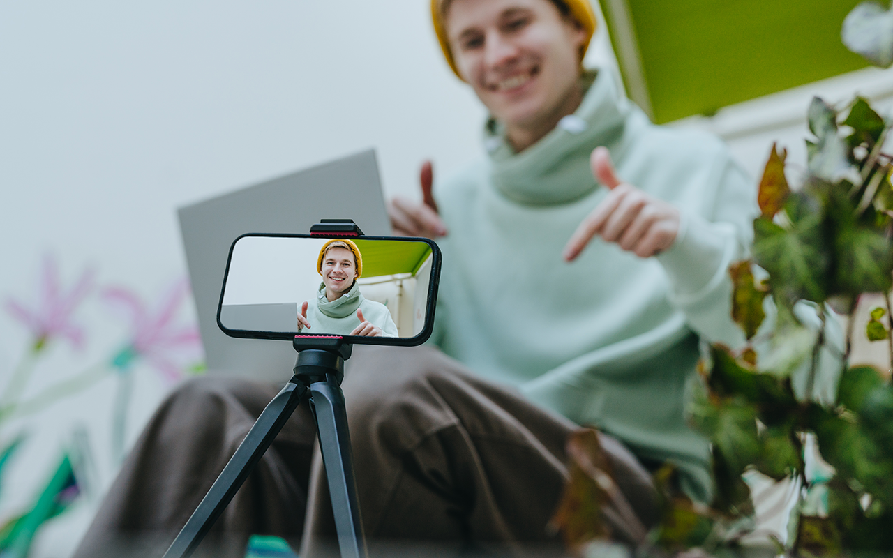 Man filming himself on a phone held by a tripod