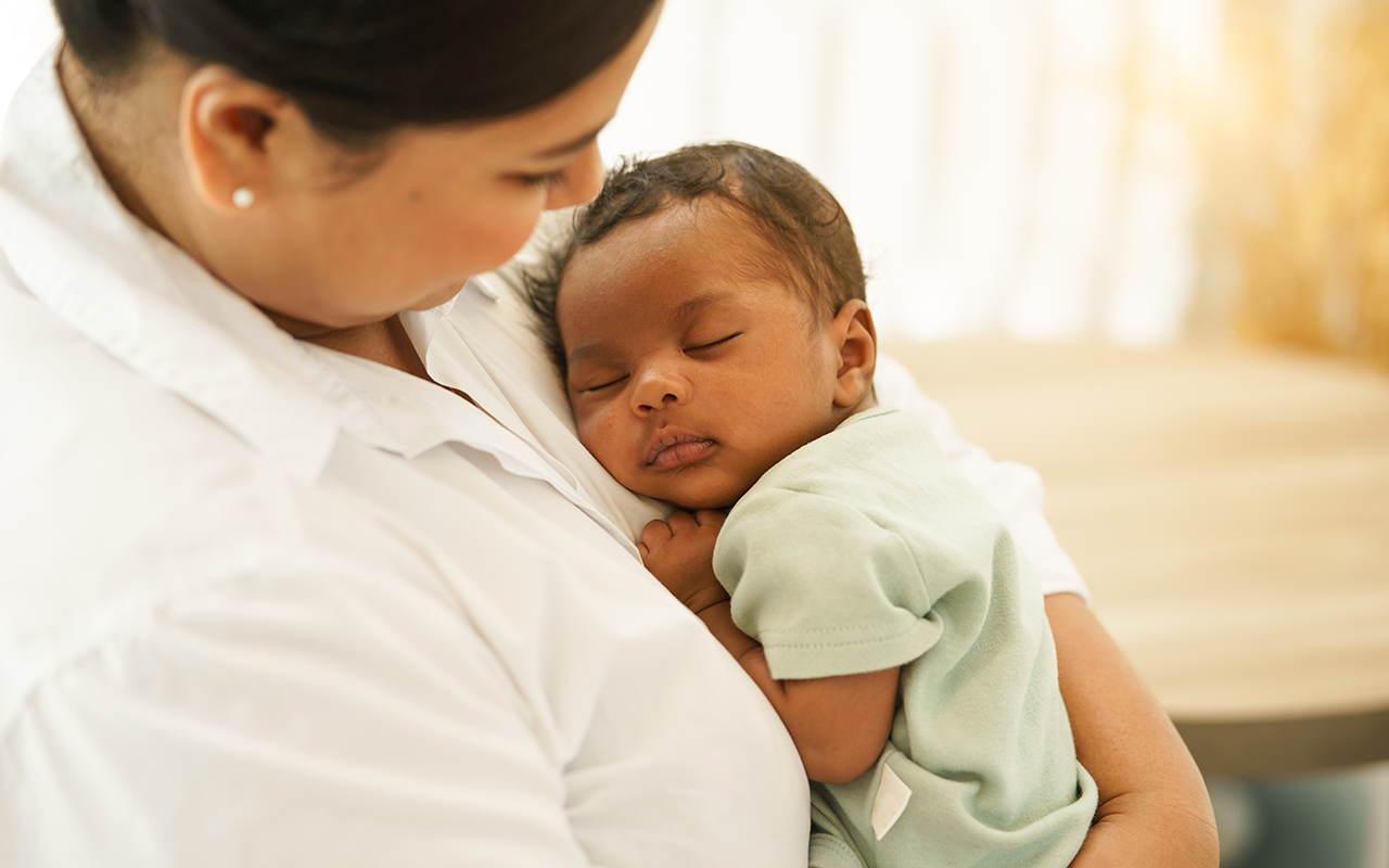 Latina mother holding young infant