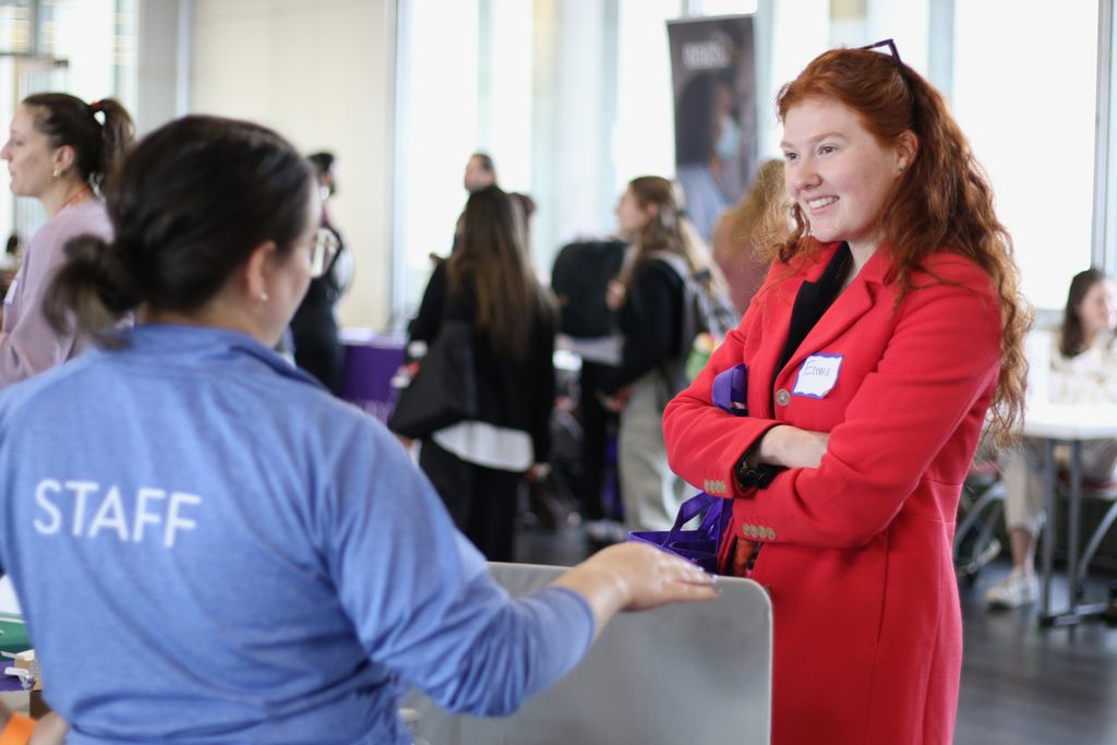 A student speaks with a staff member of a visiting organization during the spring 2025 career fair.