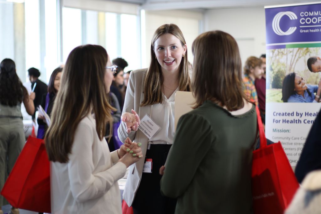 A student ambassador speaks with two of her peers during the 2025 spring career fair.