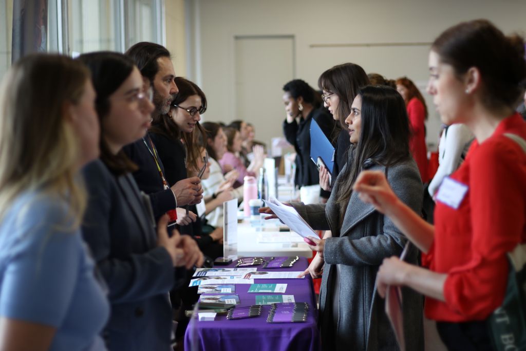 学生 speak with staff from visiting organizations at the spring 2025 career fair.
