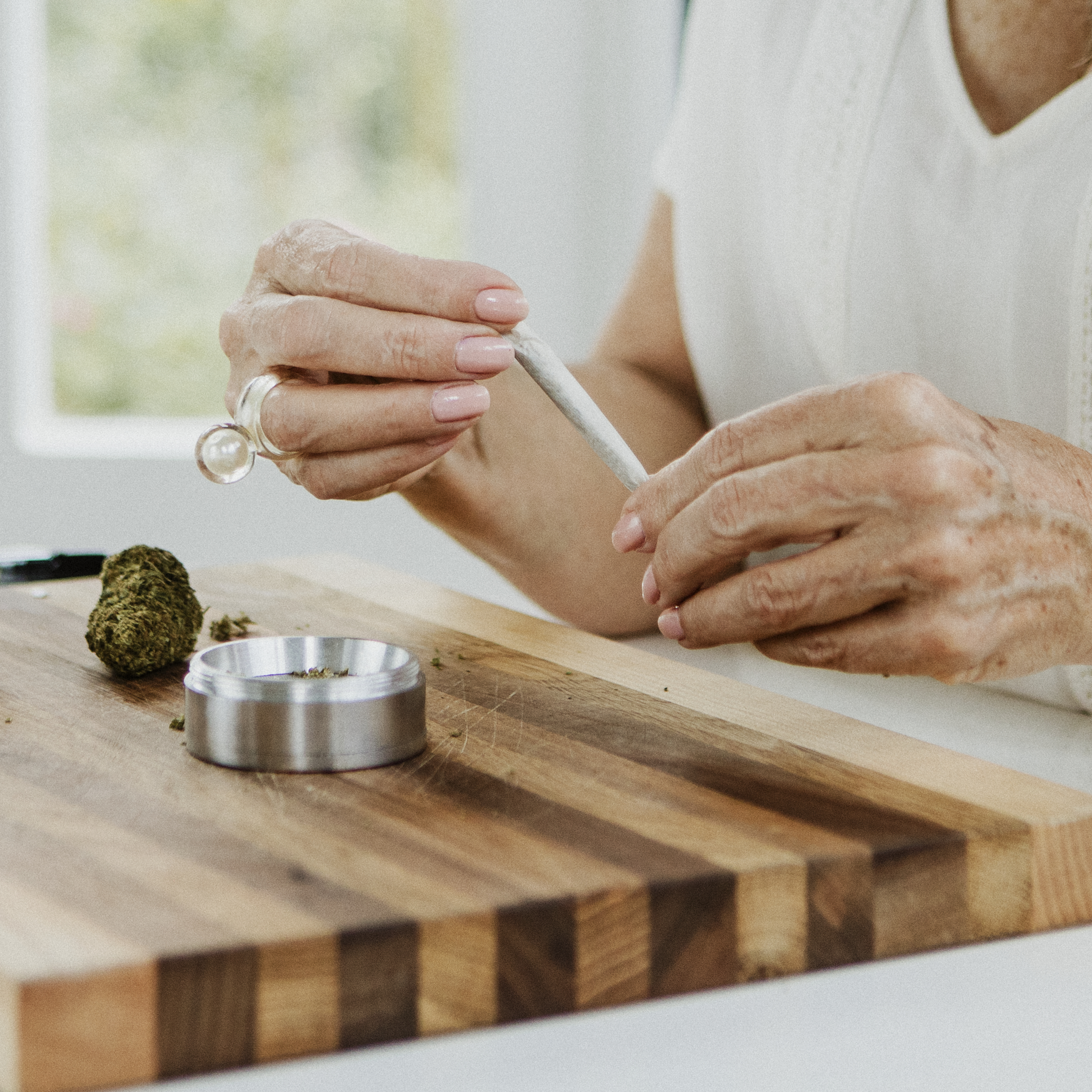 Senior woman making a weed joint at home