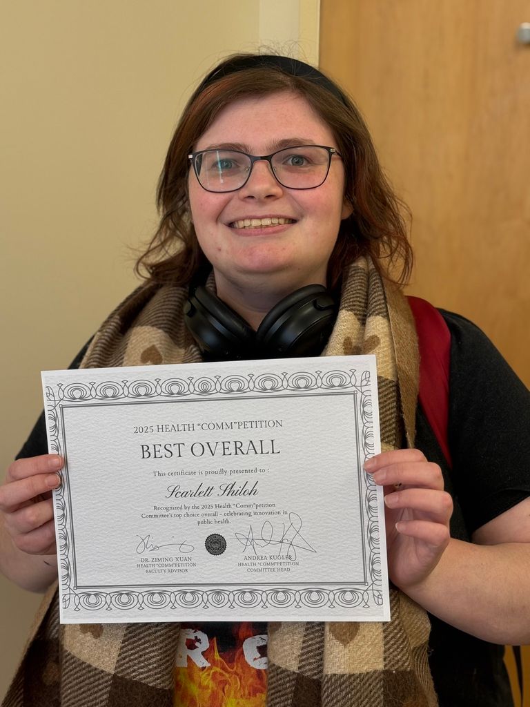 斯佳丽示罗 poses with her certificate for winning the 2025 Health "Comm"petition best overall award.