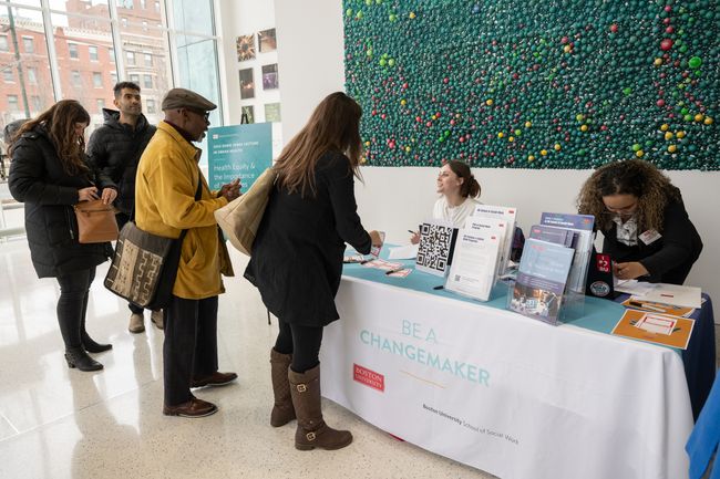 Registration table at lecture with event attendees and branded items on table