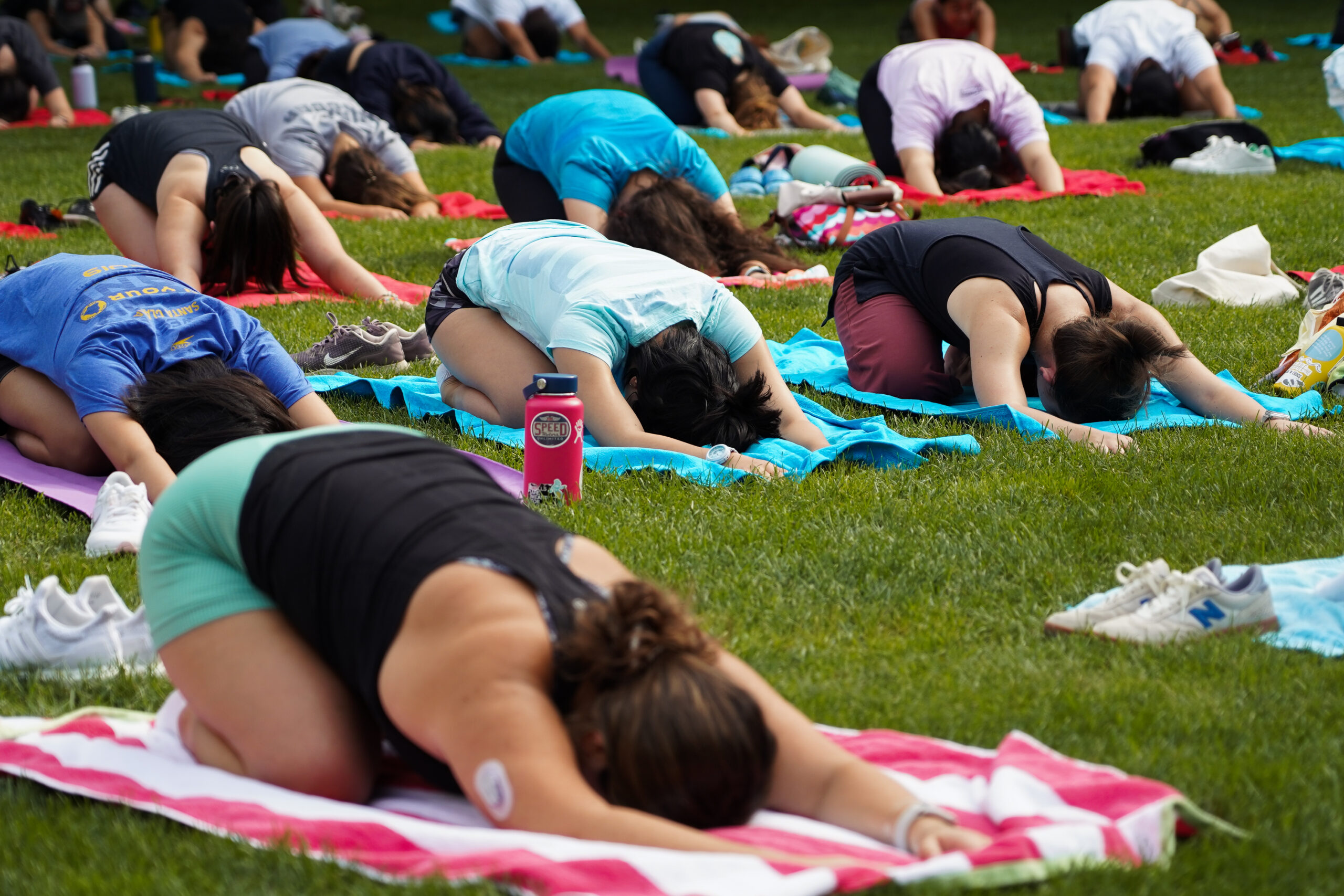 Students participate in a yoga class at BU Beach, part of Boston University's Charles River campus.