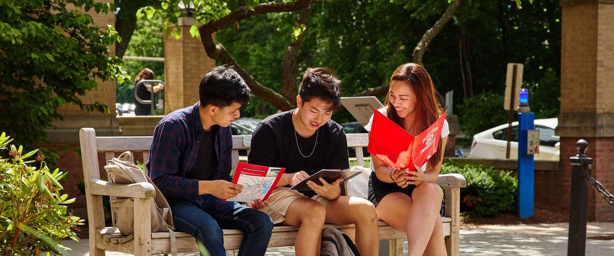 Three Boston University have a few laughs on a bench