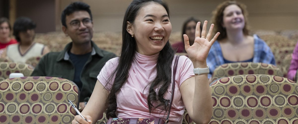 Boston University student raising hand in classroom