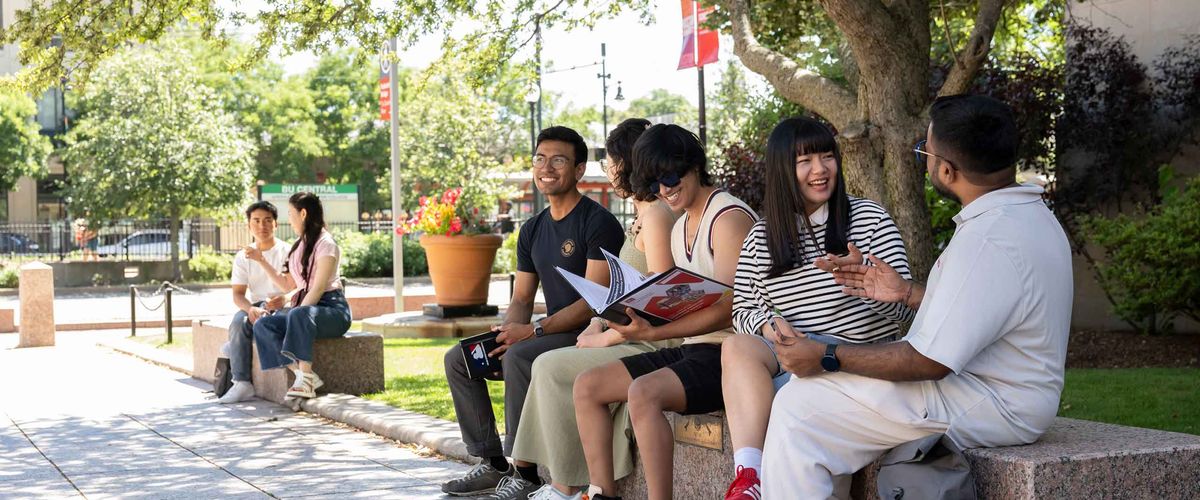 BU Students sitting along a bench