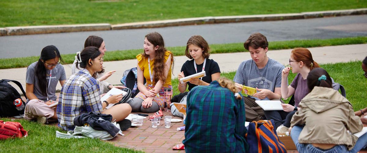 A group of BU Summer Term high school students socializing on a brick pathway outdoors