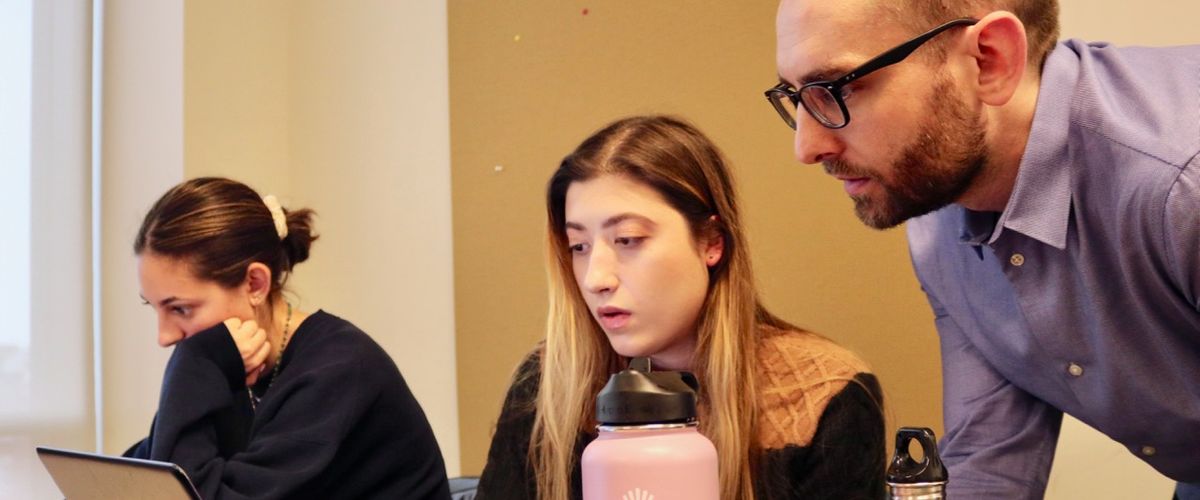 An instructor and two students work in a classroom