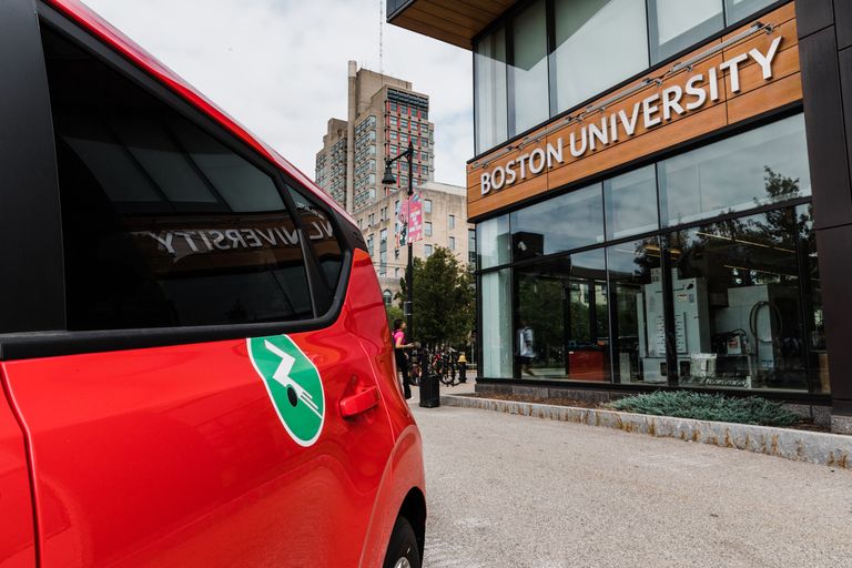 Red car with Zipcar logo parked next to BU EPIC.