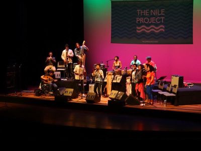 The Nile Project band onstage with colorful backdrop