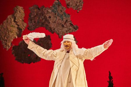 Theatre Nohgaku actor in costume against red backdrop