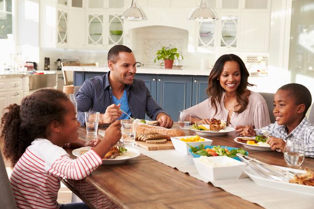 Parents and their two children eating at kitchen table