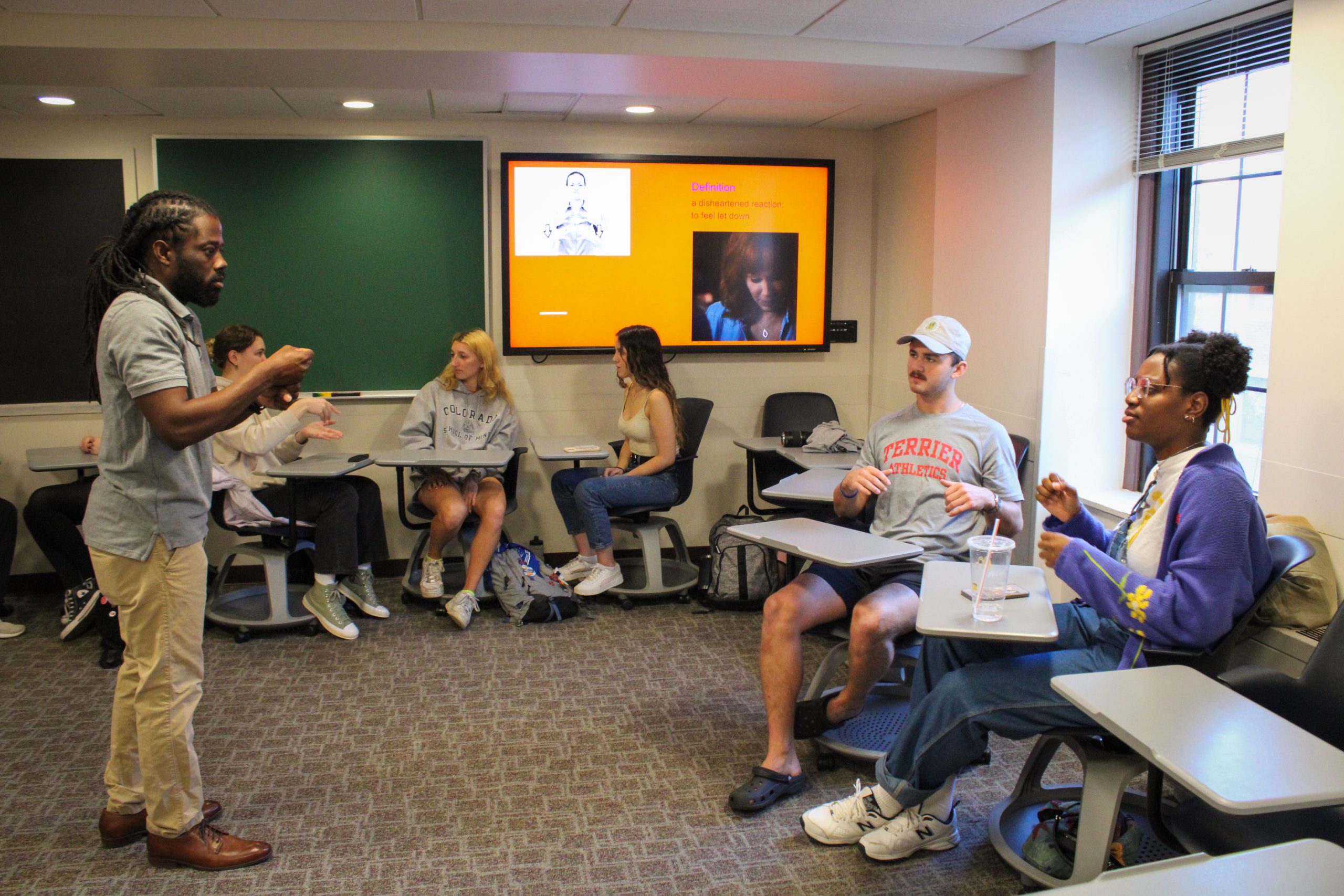 Shows a faculty member teaching ASL to five college students