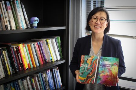 Shows faculty member Grace Kim holding two books