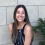 Shows Lauren Shoss seated in front of a building 