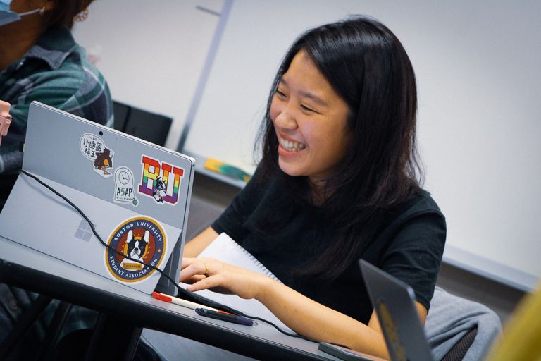 Student smiles looking at her computer