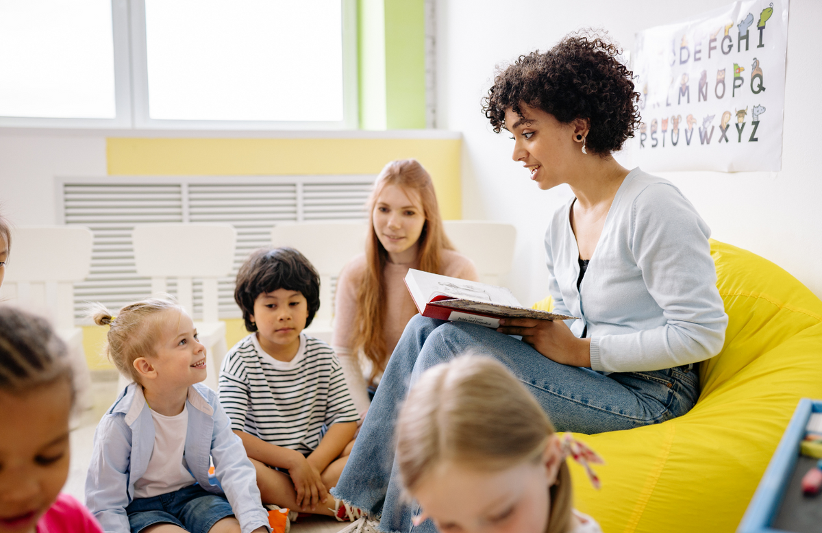 young teacher reading to students in elementary classroom