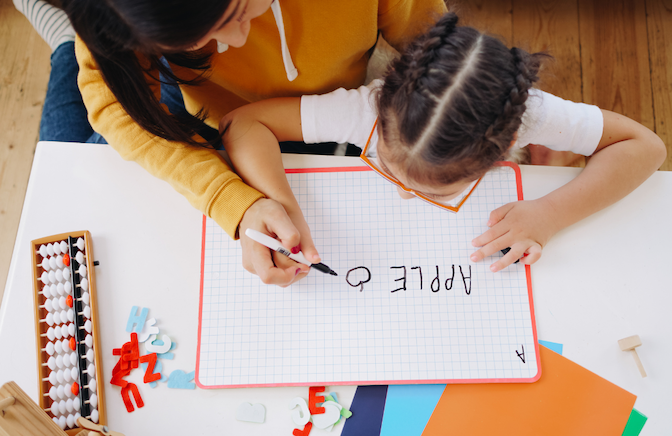 teacher teaching small girl