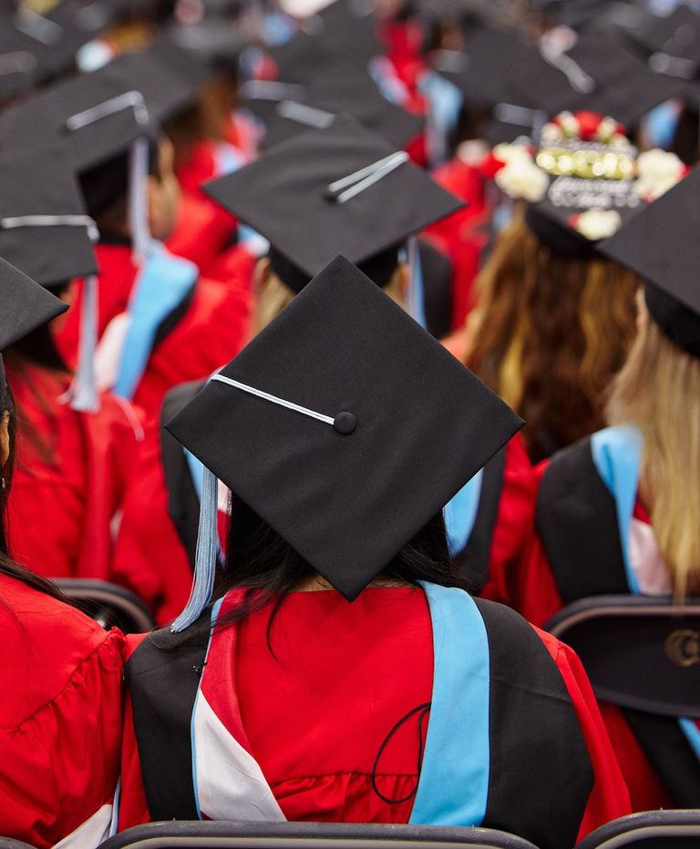 Back of students sitting in their cap and gown at commencemnt