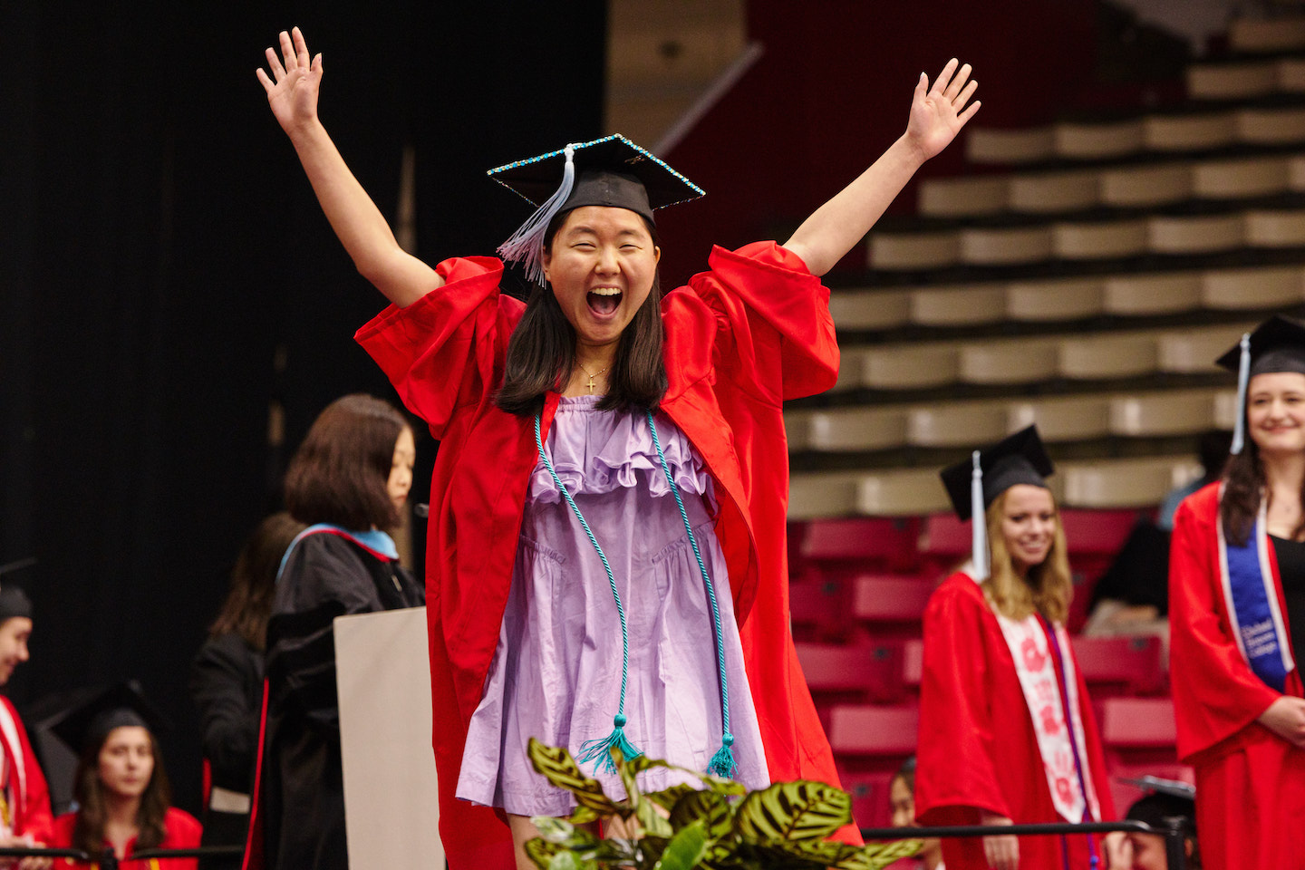 BU Wheelock student celebrating her graduation as she walked across the stage