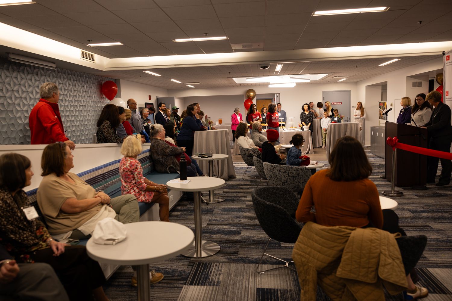 People watching ribbon cutting 
