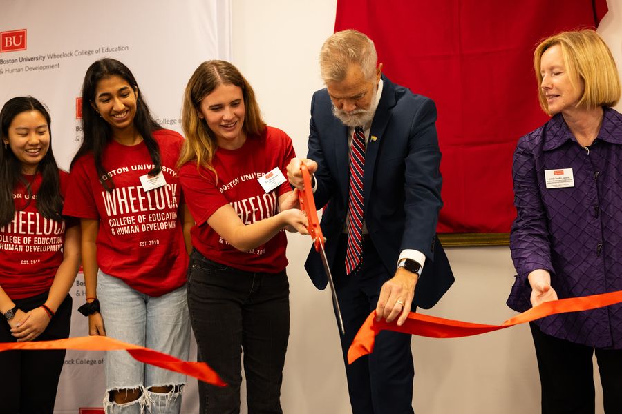 Dean David Chard alongside students cutting a ribbon at the reopening of 2 Silber Way's Lobby