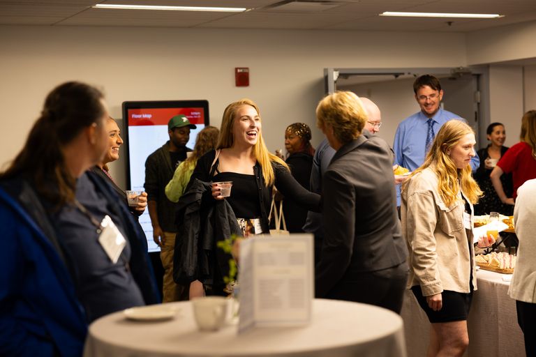 Attendees greeting each other at the ribbon cutting.