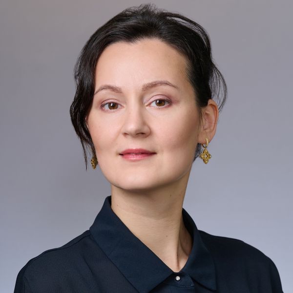 Photo of Polina Zvereva, who is wearing her dark hair up and a dark blue shirt