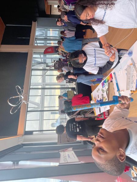 A student tries an science experiment at an informational table