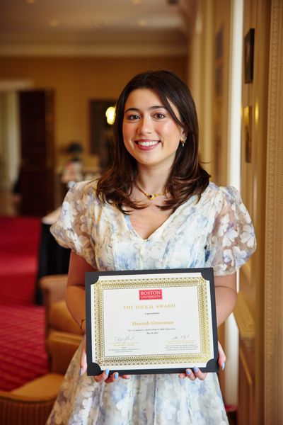 Shows Hannah Grossman holding an award