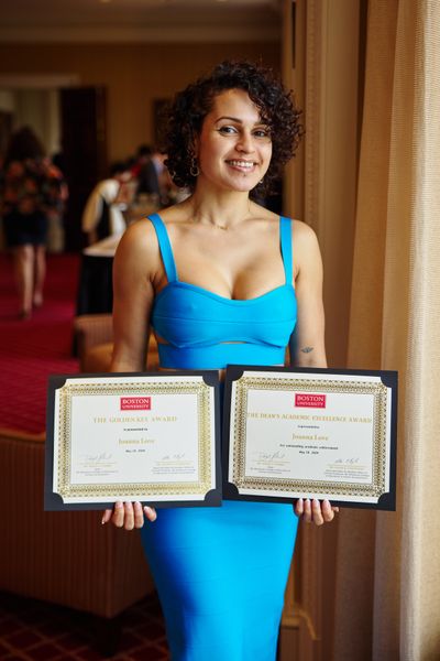 Shows Joanna Love holding two awards