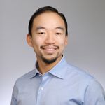 Shows Michael Chang, who has short black hair and is wearing a blue collared shirt