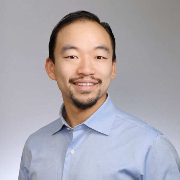 Shows Michael Chang, who has short black hair and is wearing a blue collared shirt