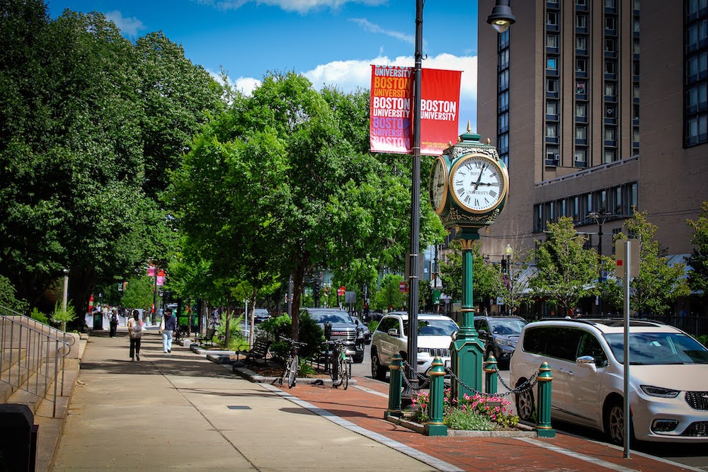 Picture of Commonwealth Ave on the BU campus with the BU Clock and a street banner reading Boston University
