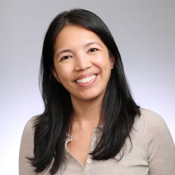 Shows Pia Caronongan, who has long black hair and is wearing a tan shirt