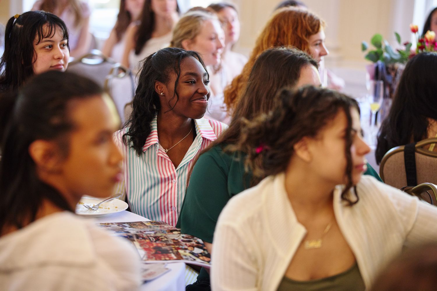 A group of people are sitting in a room at tables